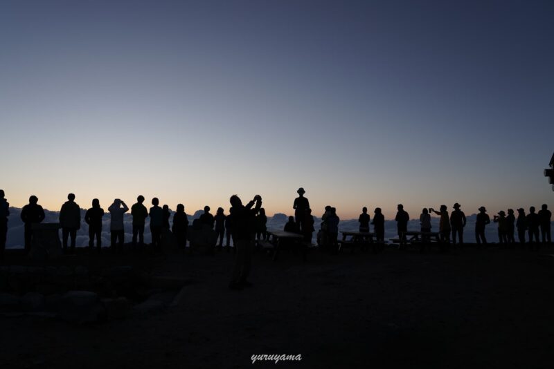 燕山荘の前で日の出を待つ登山者たち