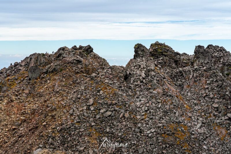 七高山から見える鳥海山山頂と登山者の画像