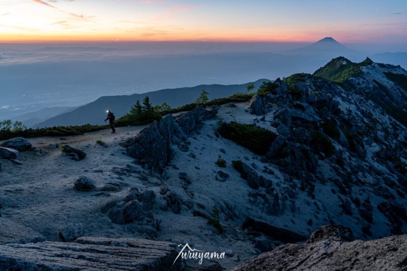 薬師岳と富士山と登山者の画像